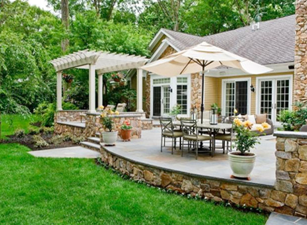 Backyard raised patio with wooden pergolas and patio furniture.